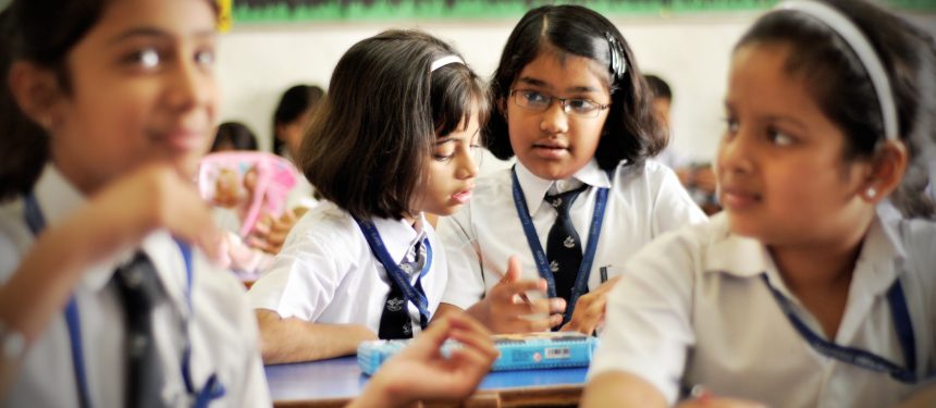 A group of girls from an all girls school in their classroom in the middle of a lesson